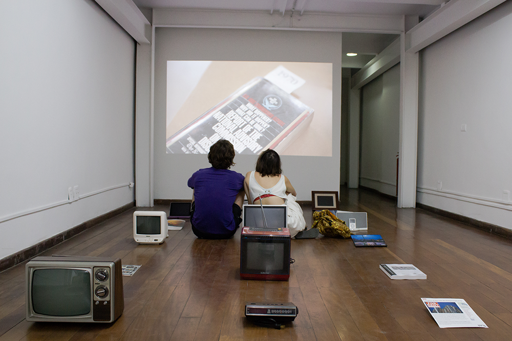 Two people in exhibition space looking at a projection