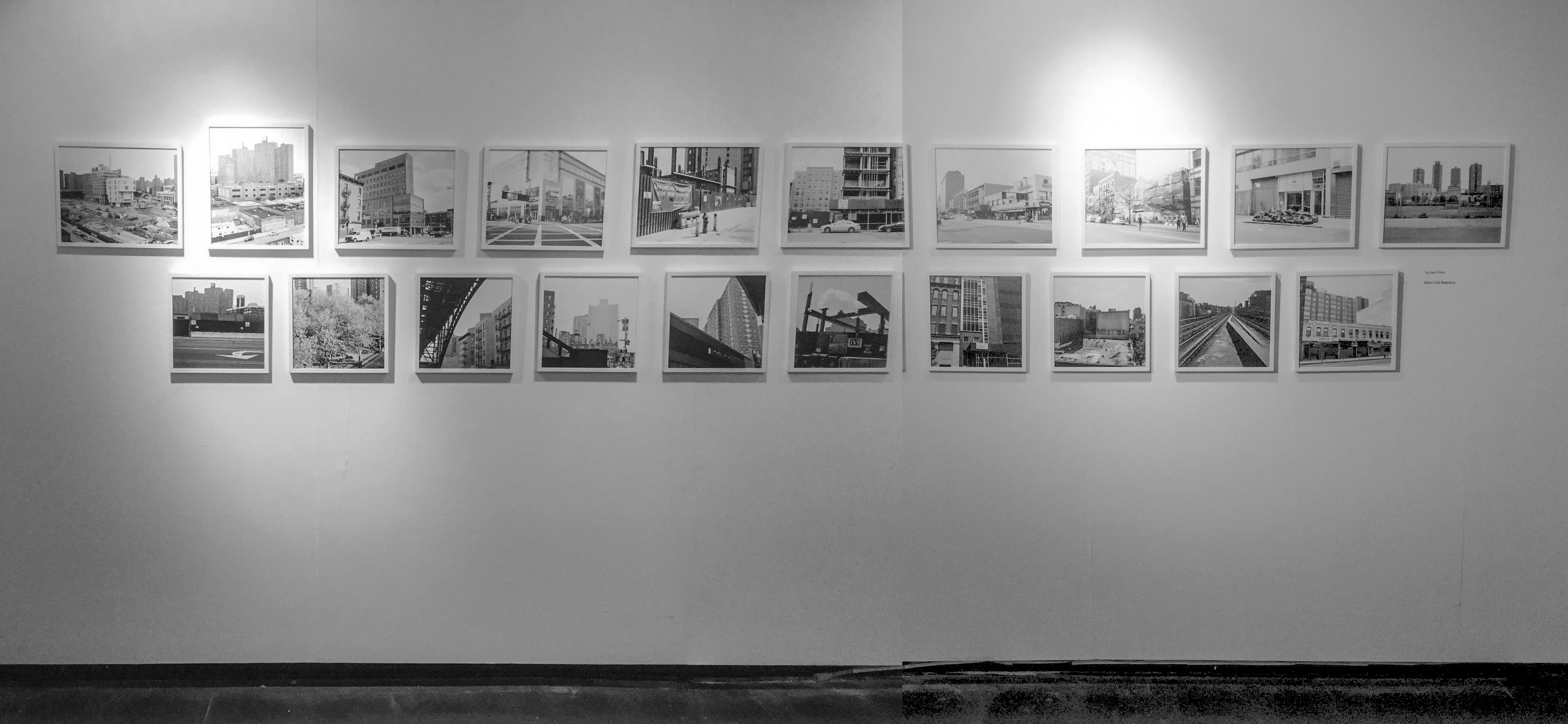 Black and white photograph featuring photographs presented on the wall