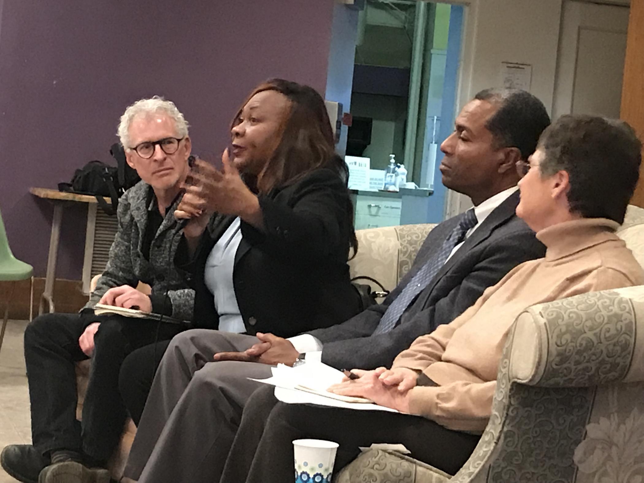 A woman speaking passionately as other panelists listen.